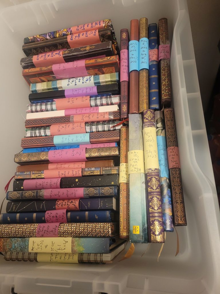 A plastic tub filled with written-in journals.