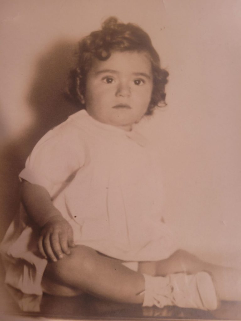 Baby girl sitting for a portrait in 1936.